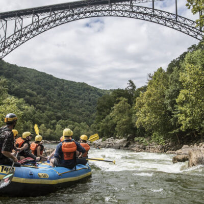 a group in a raft under the famous bridge