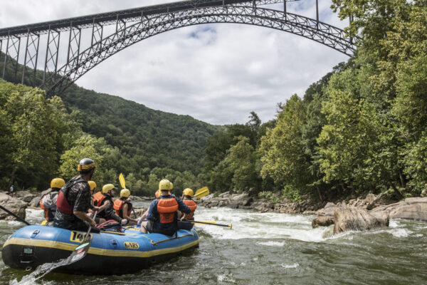 a group in a raft under the famous bridge