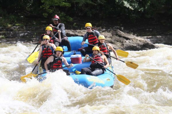 a group of rafters about to dip down into the water with smiles on their faces