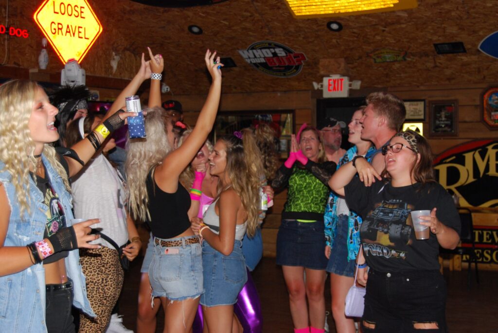 a group of people in 80s clothes dancing