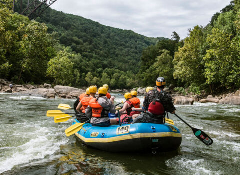 boat calmly floats under bridge River Expeditions West Virginia