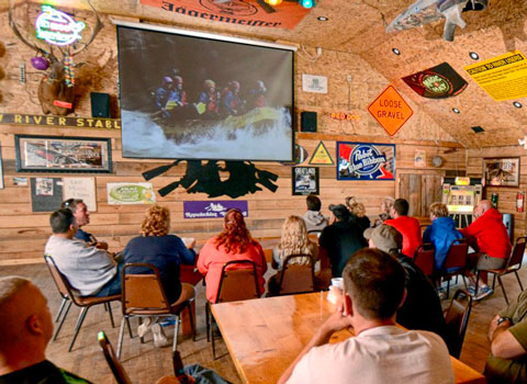 group of rafters view their trip photos at the restaurant River Expeditions West Virginia