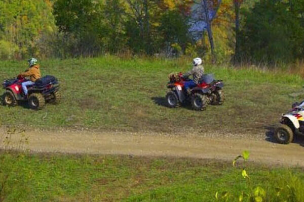 a group of 5 people on ATVs on a trail