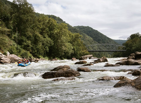 rafting group avoid rocks as they float down the river at River Expeditions West Virginia