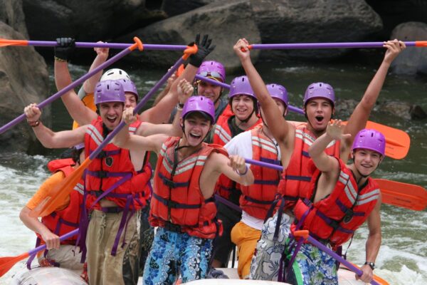 a scout group of boys standing in a raugh laughing and smiling