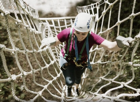 a woman climbing a rope ladder